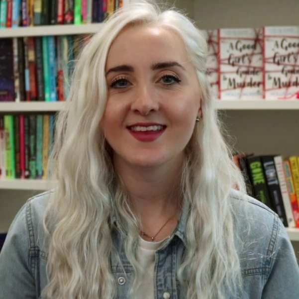1000023119 novelist standing in front of her published books