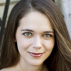 POPULAR STORYTELLER WITH LIGHT BROWN EYES SMILING